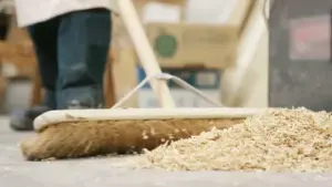 Depositphotos 105308130 stock video man sweeping up sawdust