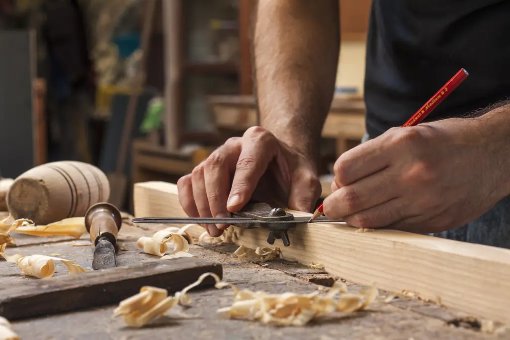 Hand Of A Carpenter Taking Measurement Of A Wooden Plank